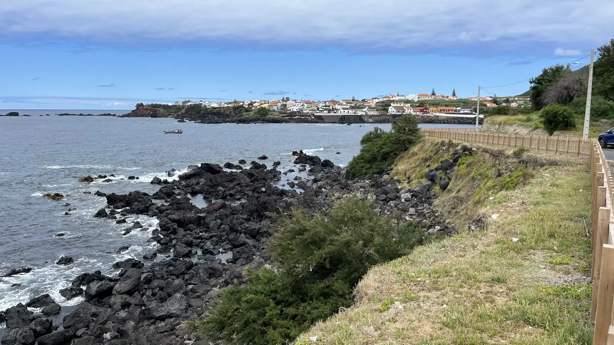 Uma vila costeira açoriana vista de uma costa de lava negra