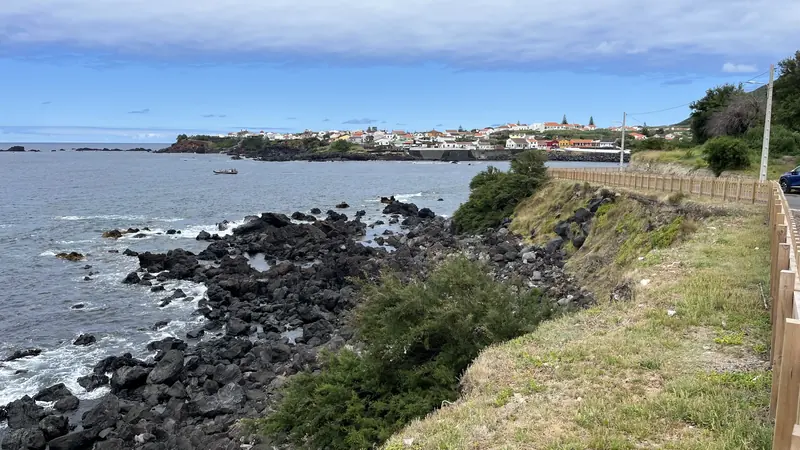 Uma vila costeira açoriana vista de uma costa de lava negra